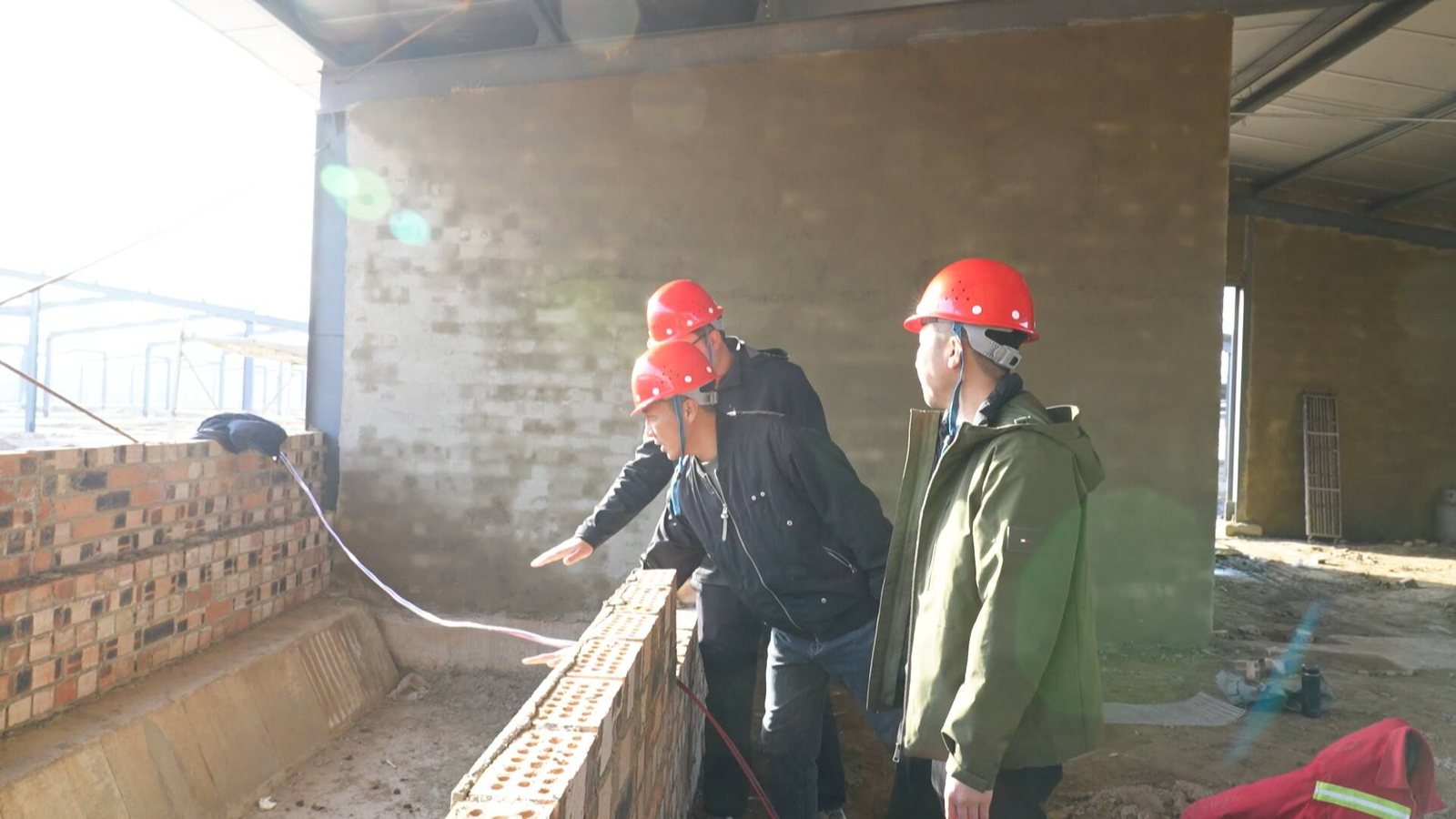 冠源农牧项目建设现场，施工人员正在检查圈舍砌筑